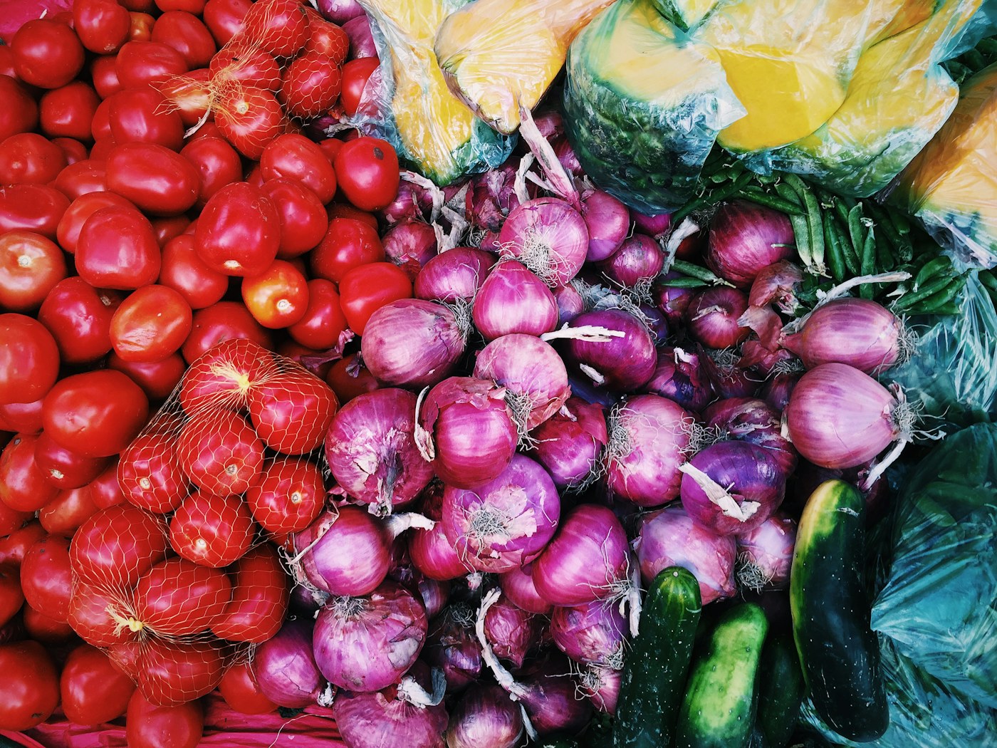 A colorful spread of fresh tomatoes, onions and produce, ready to be cooked into meals